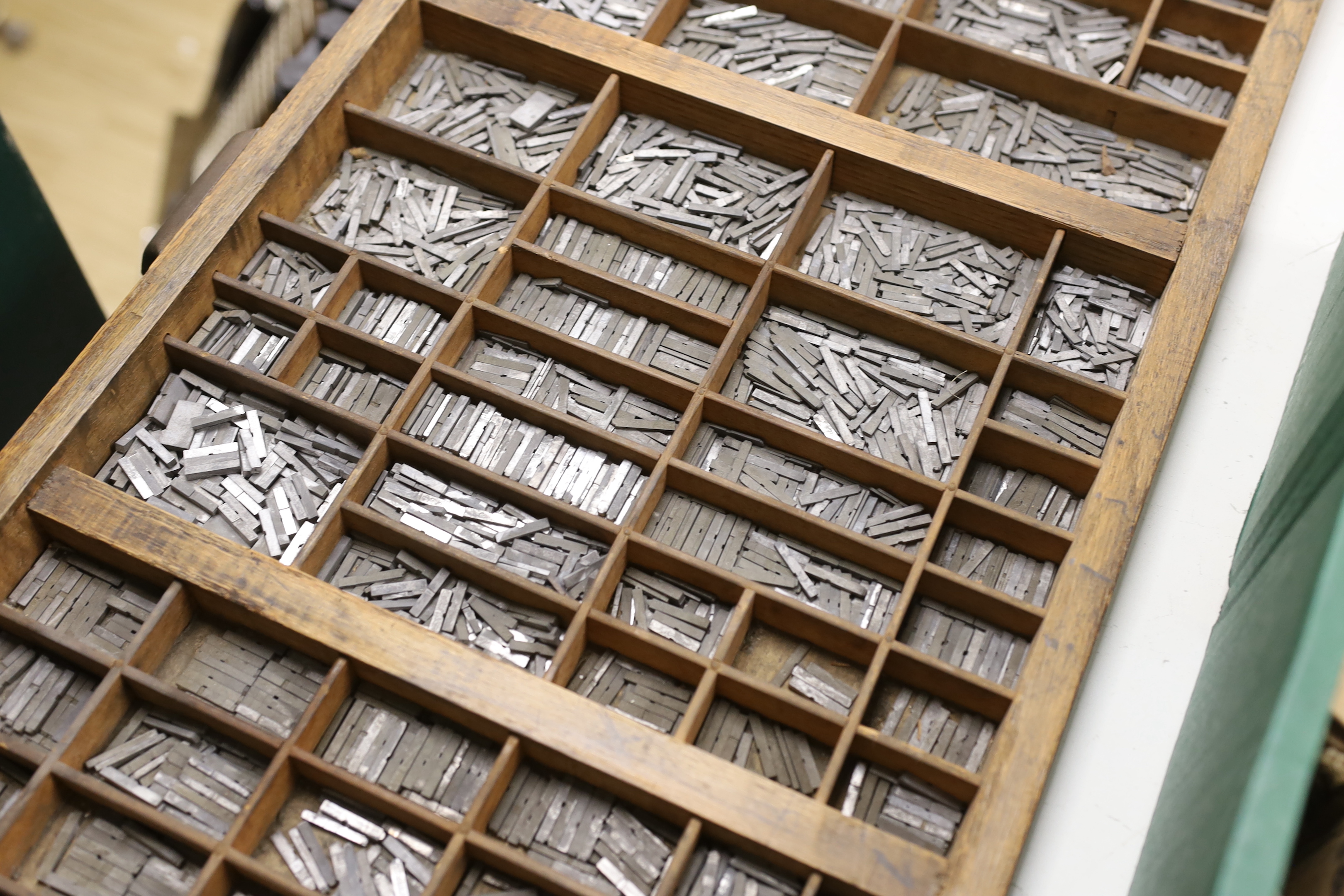 A wooden drawer with dividers as a printer's tray of type set, originally from The Argus building, Brighton, 82 x 36cm